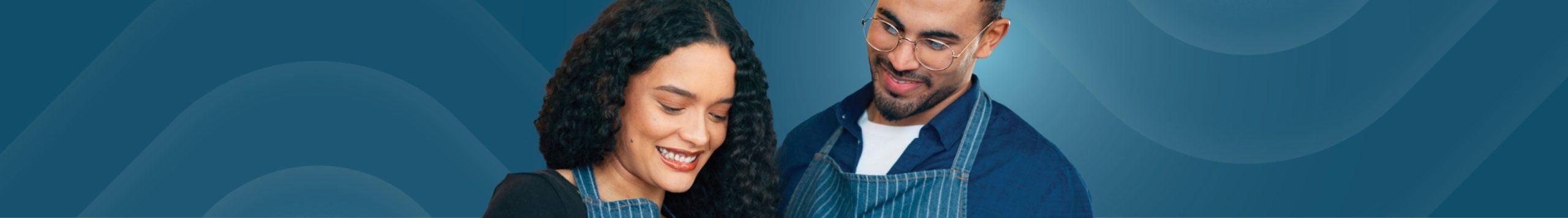 A man and woman smile while working at a small business.